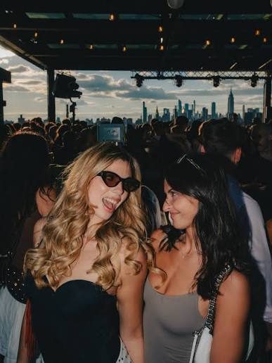 Two friends enjoying a rooftop party